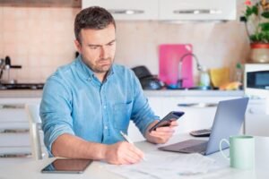 henkilo pohtimassa budjettiaan kotona