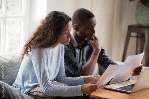 henkilo tarkastelemassa lainapapereita kotona