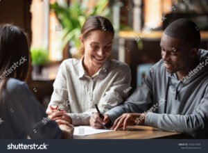 hymyileva asiakas allekirjoittaa asuntolainasopimuksen