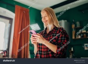 hymyileva henkilo kayttaa mobiililaitetta tunnistautumiseen