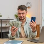 Voinko saada asuntolainaa ilman vakituista työsuhdetta hymyileva-henkilo-laskemassa-budjettiaan-kotona