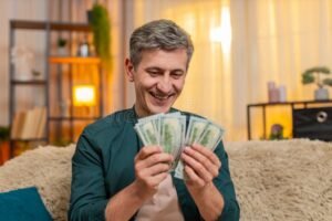 hymyileva ihminen laskemassa rahat katensa paalla