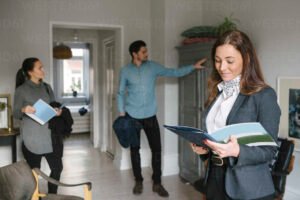 hymyileva pariskunta katsomassa taloesitetta