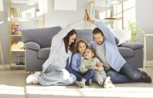 hymyileva perhe kodin turvassa