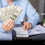 ihminen-laskee-talouspapereita-poydan-aaressa