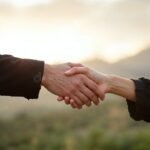 kaksi-ihmista-kattelemassa-sopimusta-ulkona