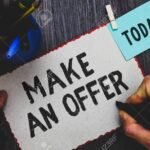 Miten Kirjoittaa Toimiva Asunnon Ostotarjousmalli kasi-kirjoittamassa-tarjouspaperia-poydalla