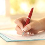 kasi-tayttamassa-lomaketta-poydalla