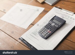 lainanlaskuri ja talousasiakirjat poydalla