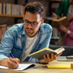 Voiko Opintolainaa Saada Ilman Opintorahaa nuori-opiskelija-kirjastossa-lukemassa-kirjaa