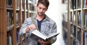 opiskelija lukemassa kirjaa kampuksella