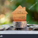 puinen-talomalli-rahapinojen-paalla