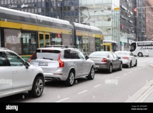 valkoinen auto liikenteessa suomen maisemassa