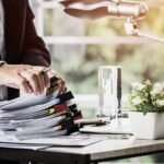 yrittaja-jarjestaa-paperit-poydalla