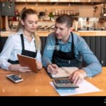 yrittaja-laskee-kulut-poydan-aaressa