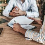 yrittaja-tutkii-vakuutussopimuksia-tyopoydan-aaressa