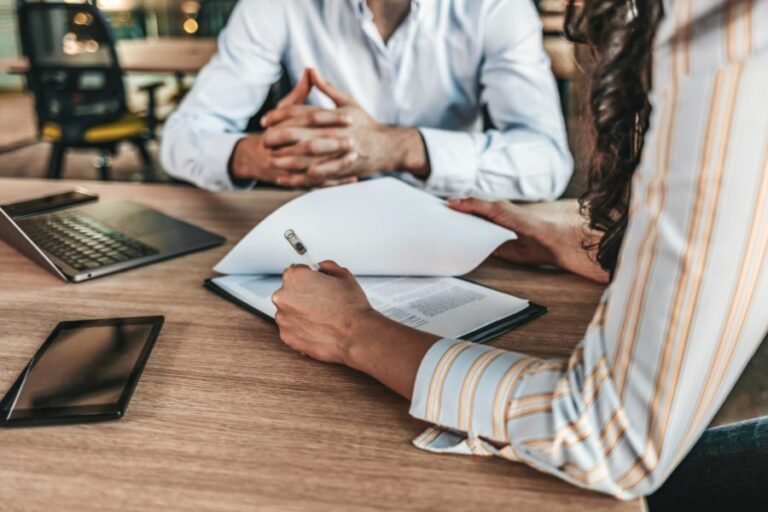 yrittaja tutkii vakuutussopimuksia tyopoydan aaressa